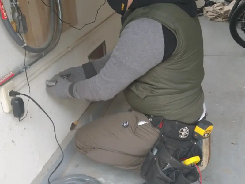 Electrician performing outlet wiring in a Upland garage